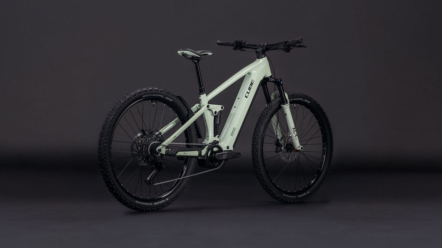 Das CUBE Stereo Hybrid ONE22 Pro 800 stonegrey'n'black 2026 E-Mountainbike, ausgestattet mit dicken, robusten Reifen, einem stabilen Rahmen und Bosch CX Antrieb, wird auf einem dunklen Hintergrund mit Seiten- und Heckwinkeln gezeigt.