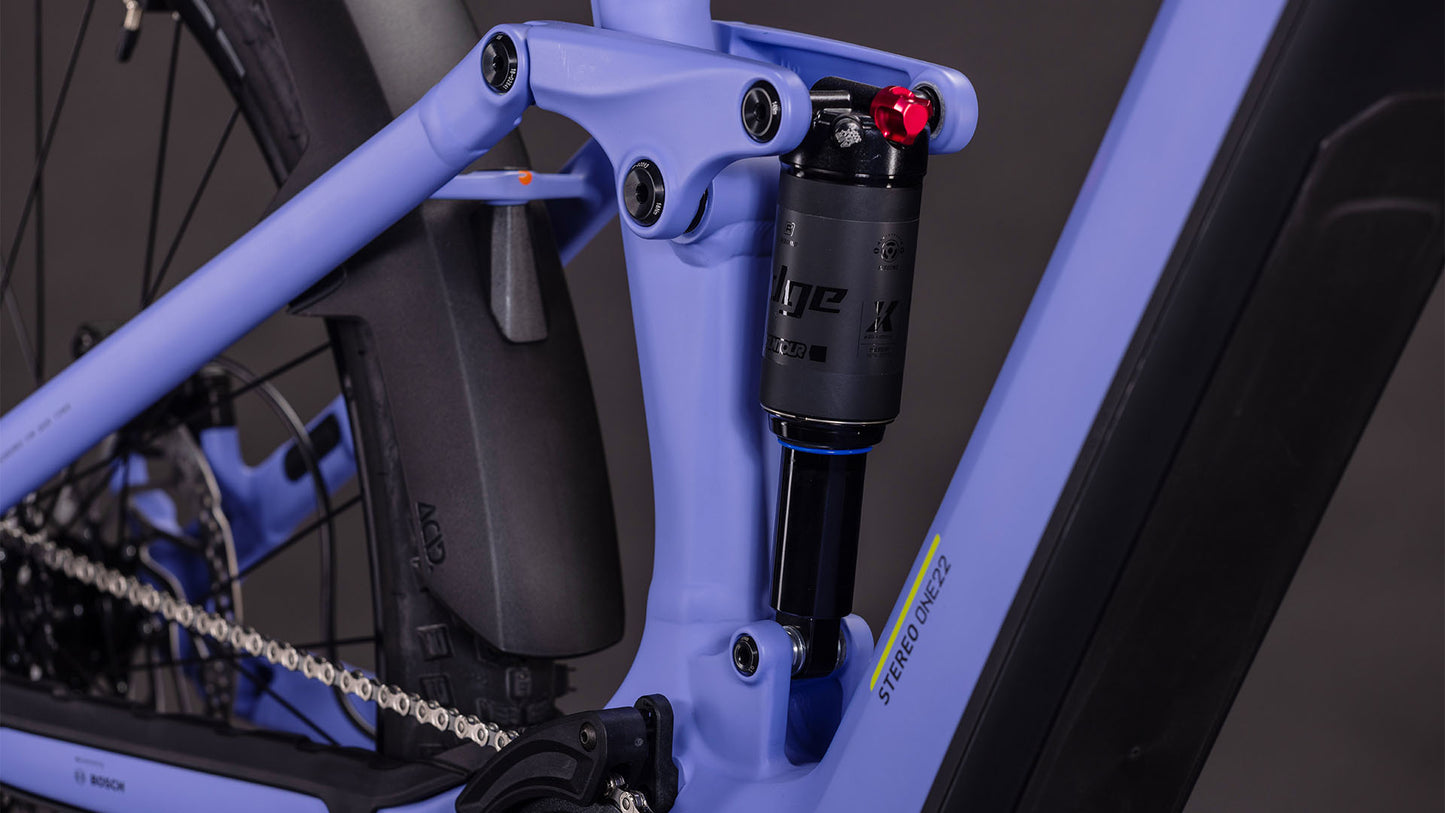 Nahaufnahme eines CUBE Stereo Hybrid ONE22 Pro 800 lucidlilac'n'lime 2026 Rahmens mit Dämpfer, Kette, Antriebsdetails, STEREO HYBRID Branding und fortschrittlicher CUBE Kinematik am Rahmen.