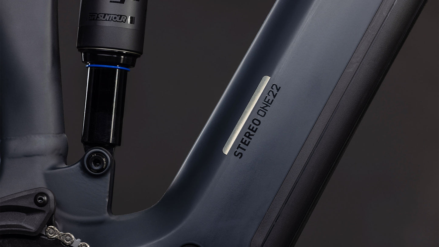 Nahaufnahme des CUBE Stereo Hybrid ONE22 Pro 800 FE night'n'chrome 2026 Rahmens, die einen Teil der Hinterradaufhängung und den integrierten Bosch CX Motor vor einem dunklen Hintergrund zeigt.