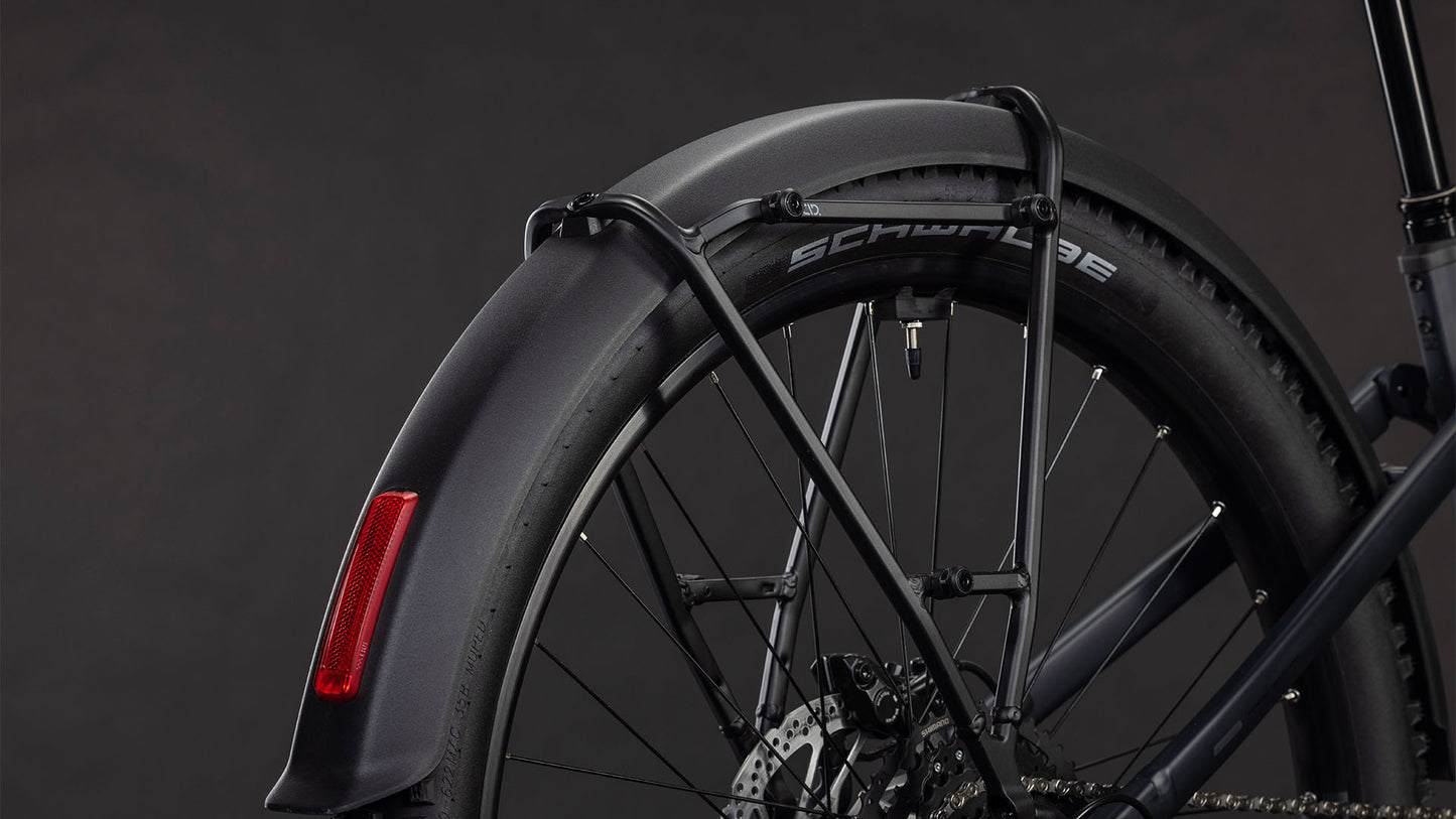 Nahaufnahme des Hinterrads des CUBE Stereo Hybrid ONE22 Pro 800 FE night'n'chrome 2026 mit schwarzem Schutzblech, Rückstrahler, Schwalbe-Reifen, Shimano Cues 10-fach Schaltung und detailliertem Bremssystem vor dunklem Hintergrund.