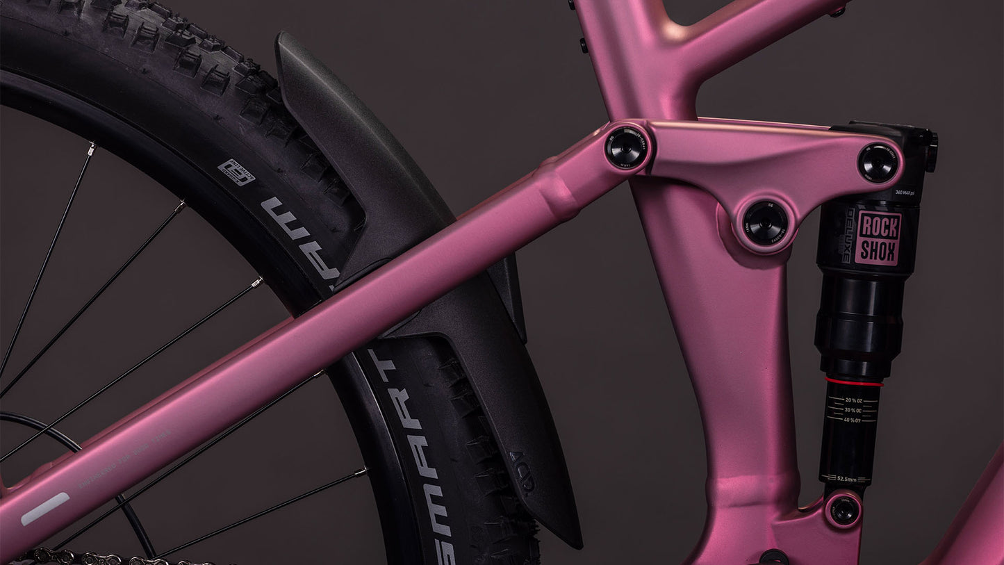 Nahaufnahme des CUBE Stereo Hybrid ONE22 Race 800 shiftblush'n'black 2026-Rahmens mit RockShox-Hinterradfederung, Smart Sam-Hinterradreifenprofil und schwarzem Kunststoffschutzblech über dem Rad.