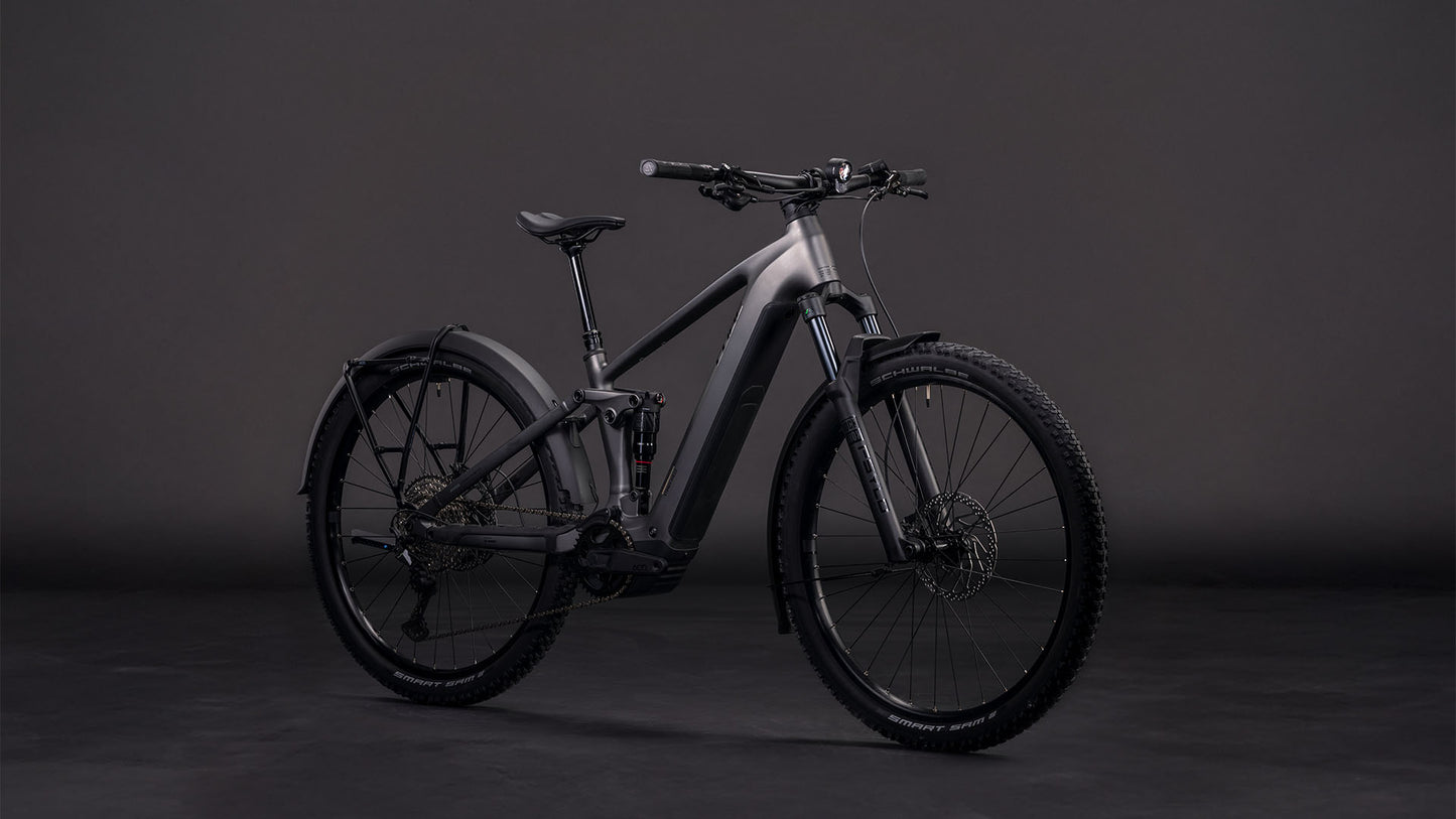 Das CUBE Stereo Hybrid ONE22 Race 800 FE slabgrey'n'chrome 2026, ein modernes E-Mountainbike mit Bosch CX-Motor, Vollfederung und dicker Bereifung, wird vor dunklem Hintergrund in Szene gesetzt.