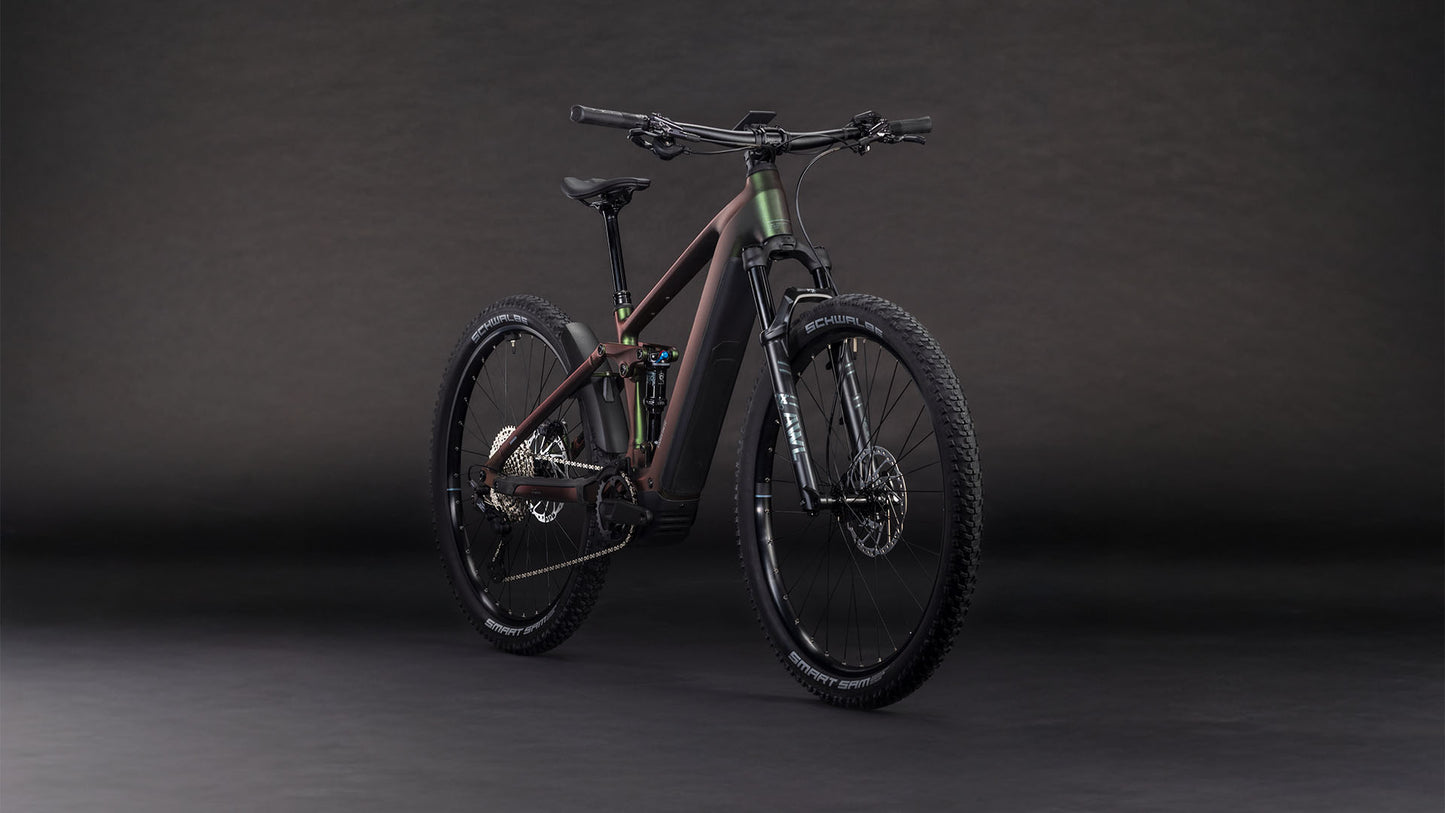 Das Cube Stereo Hybrid ONE22 SLX 800 stellar'n'green 2026 von CUBE verfügt über einen matten, dunklen Rahmen, einen Bosch CX-Antrieb, eine Shimano XT 12-Gang-Schaltung, eine Vorder- und Hinterradfederung, dicke Reifen mit Profil und Scheibenbremsen - schräg fotografiert auf einem dunklen, nahtlosen Hintergrund.