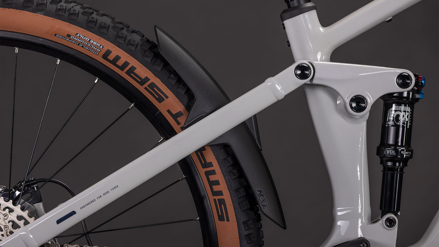 Nahaufnahme der Hinterradaufhängung des CUBE Stereo Hybrid ONE22 SLX 800 greige'n'switch 2026 mit weißem Rahmen, Bosch CX-Antrieb, Shimano XT-Schaltung, schwarzem Schutzblech und einem Laufrad mit braunem SMART SAM-Reifen.