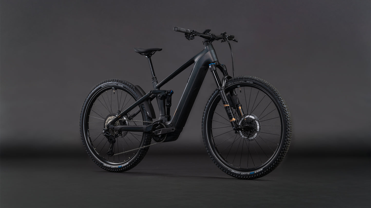 Das CUBE Stereo Hybrid ONE22 SLT 800 prizmblack'n'black 2026, ein schnittiges schwarzes E-Mountainbike mit dicken Reifen, Vollfederung, Bosch CX Antrieb, Shimano XT Di2 Teilen und Scheibenbremsen, steht vor einem dunklen, nahtlosen Hintergrund.