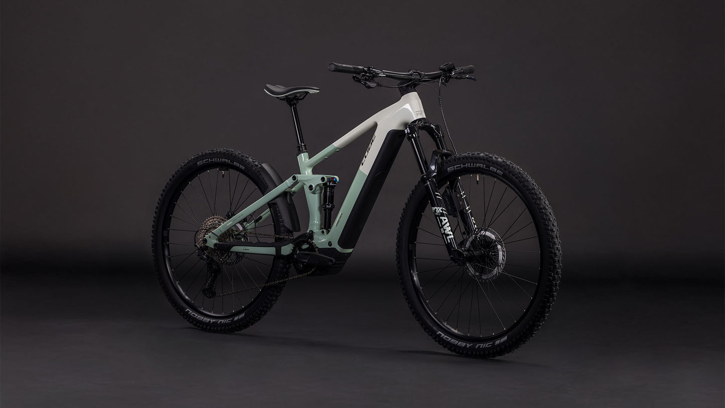Das CUBE Stereo Hybrid ONE44 EXC 800 desertstone'n'driedherbs 2026 verfügt über einen stylischen zweifarbigen Rahmen, dicke Reifen, Fox 36 Float AWL Federgabel, Shimano XT Scheibenbremsen, vor einem dunklen Hintergrund.