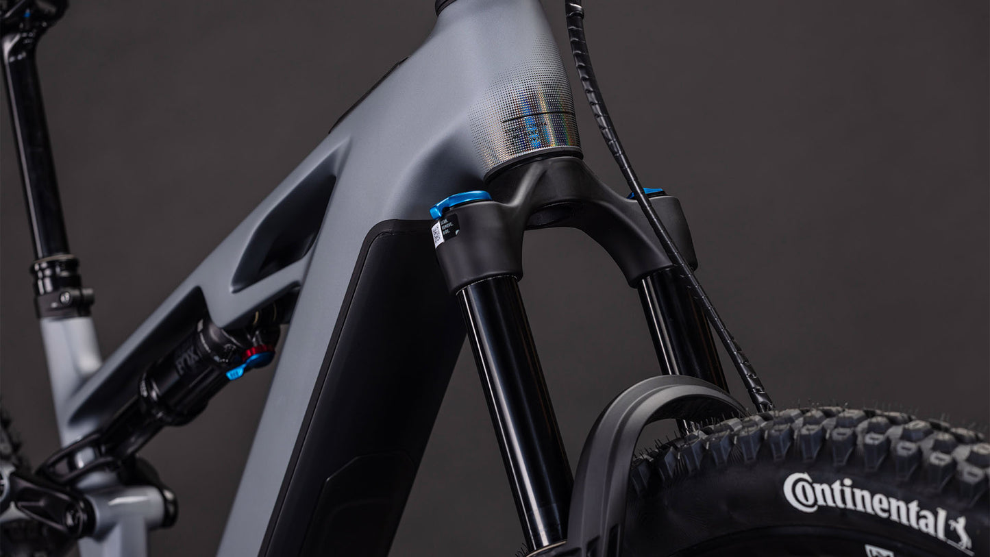 Nahaufnahme der vorderen Federgabel, des Rahmens und des Laufrads des CUBE Stereo Hybrid ONE44 HPC SLX Evo 800 mit dem Continental-Reifenbranding und einem Bosch CX-Motor auf der rechten Seite vor einem dunklen Hintergrund.