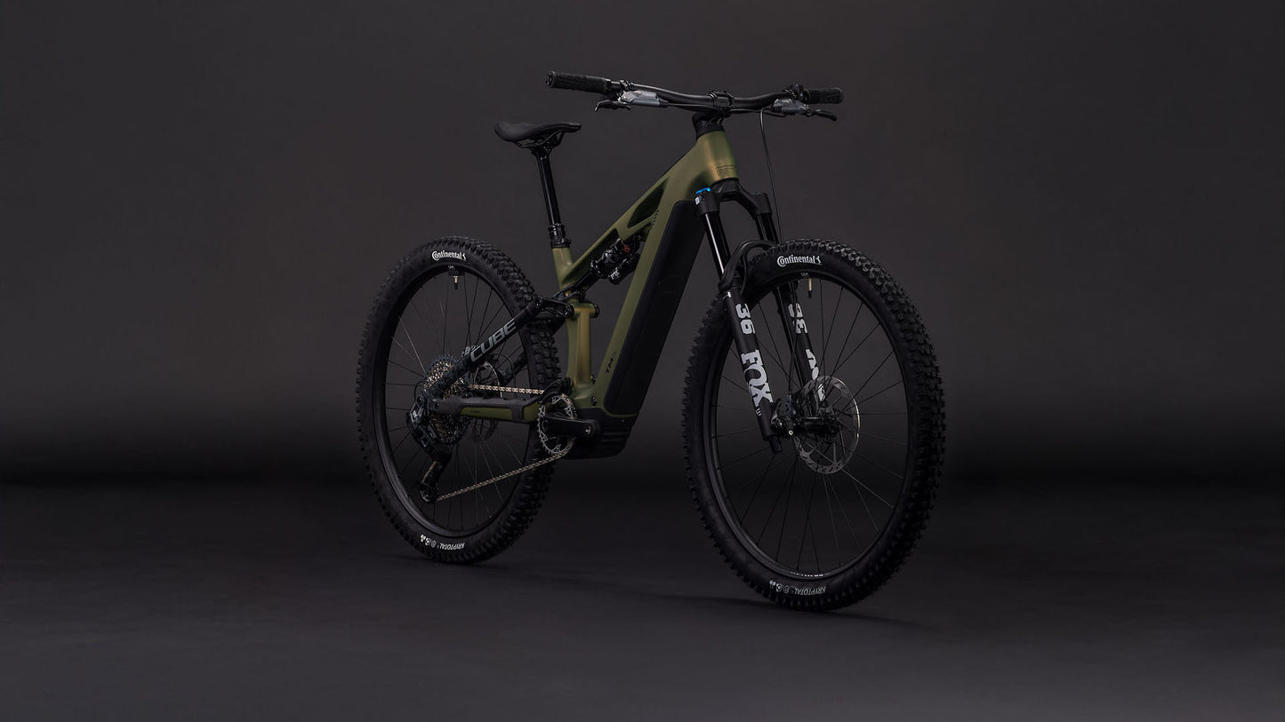 Das CUBE Stereo Hybrid ONE44 HPC TM 800 reedgreen'n'matrix 2026 E-MTB verfügt über breite Stollenreifen, einen schwarzen Lenker, Stoßdämpfer vorne und hinten und einen Bosch CX-Motor, der vor einem dunklen, nahtlosen Hintergrund steht.