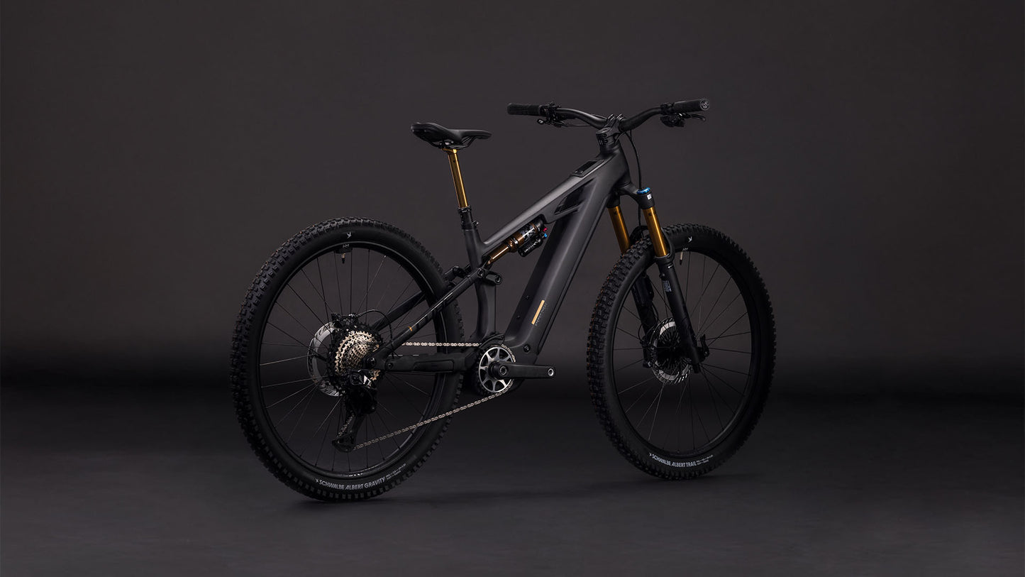 Das CUBE Stereo Hybrid ONE44 HPC AT 800 carbon'n'gold 2026 Elektro-Mountainbike besticht durch sein modernes schwarz-goldenes Design, die dicken Reifen, den Bosch CX-Motor und die auffällige goldene Federgabel, die sich auf dunklem Grund präsentiert.