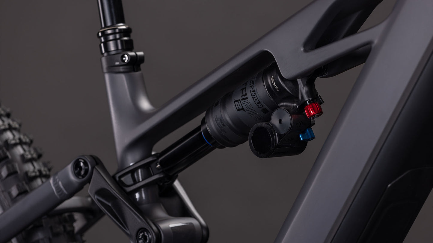 Nahaufnahme der Hinterradaufhängung des CUBE Stereo Hybrid ONE77 HPC Race 800. Hervorzuheben sind der Stoßdämpfer und das irongrey'n'black Rahmenfinish vor einem dunklen Hintergrund.