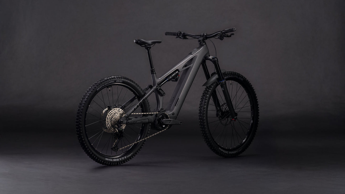 Das CUBE Stereo Hybrid ONE77 HPC Race 800 irongrey'n'black 2026 Elektro-Mountainbike ist vor einem dunklen Hintergrund abgebildet, der die dicken Reifen, den Bosch CX-Motor, den Shimano XT 12-Gang-Antrieb und die Anordnung des Akkus hervorhebt.
