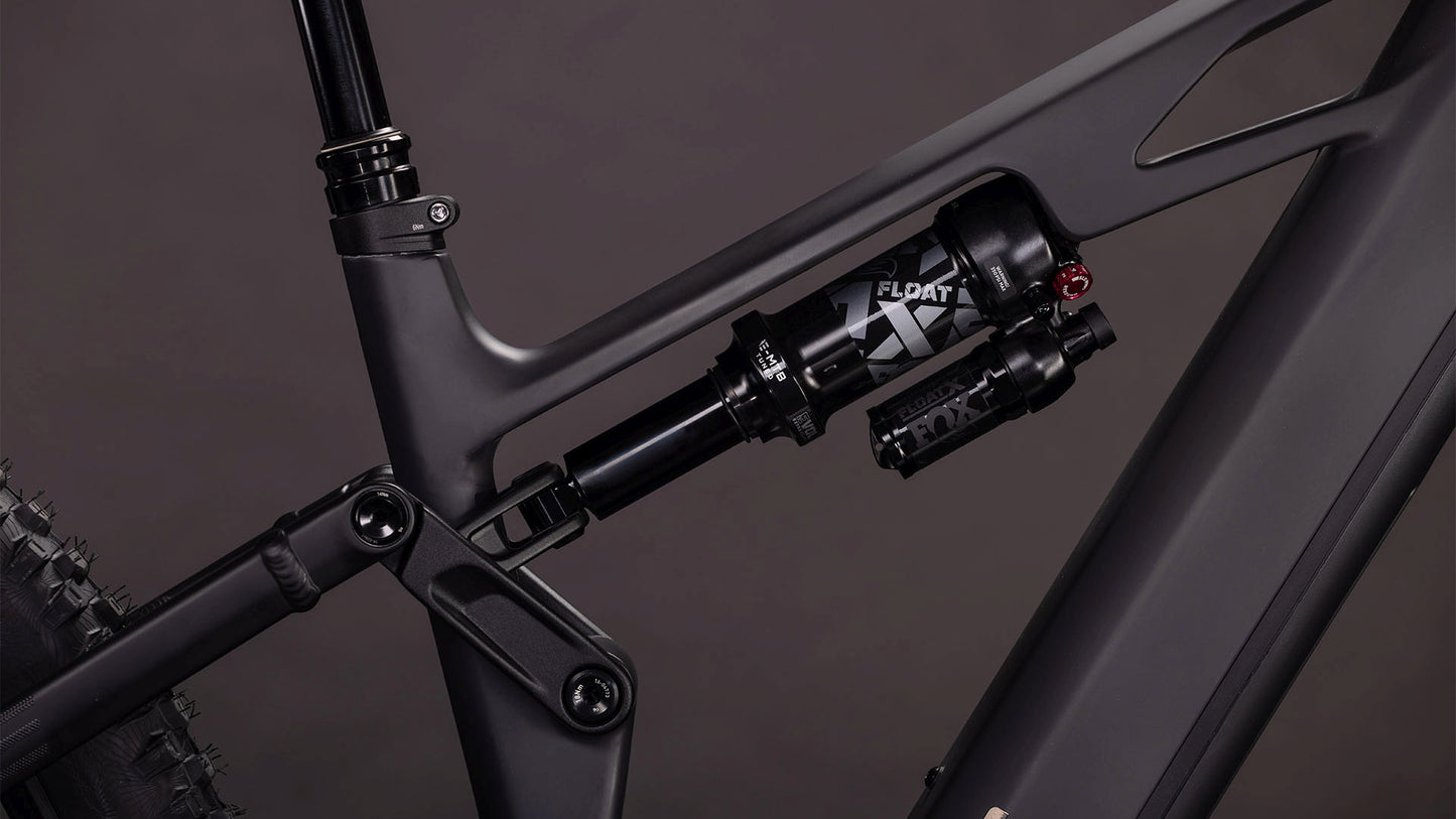 Nahaufnahme der Hinterradfederung des CUBE Stereo Hybrid ONE77 HPC SLX 800 blackline 2026 mit FOX Float X Dämpfer und detaillierter Anlenkung an einem mattschwarzen Rahmen, angetrieben von einem Bosch CX Motor für leistungsstarkes E-Mountainbiking.