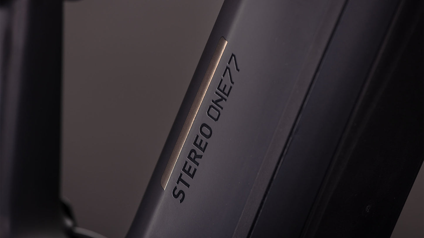 Nahaufnahme eines mattschwarzen CUBE Stereo Hybrid ONE77 HPC SLX 800-Rahmens mit fettem "STEREO ONE77"-Schriftzug, der das Fox Float 38 Rhythm-Fahrwerk hervorhebt.