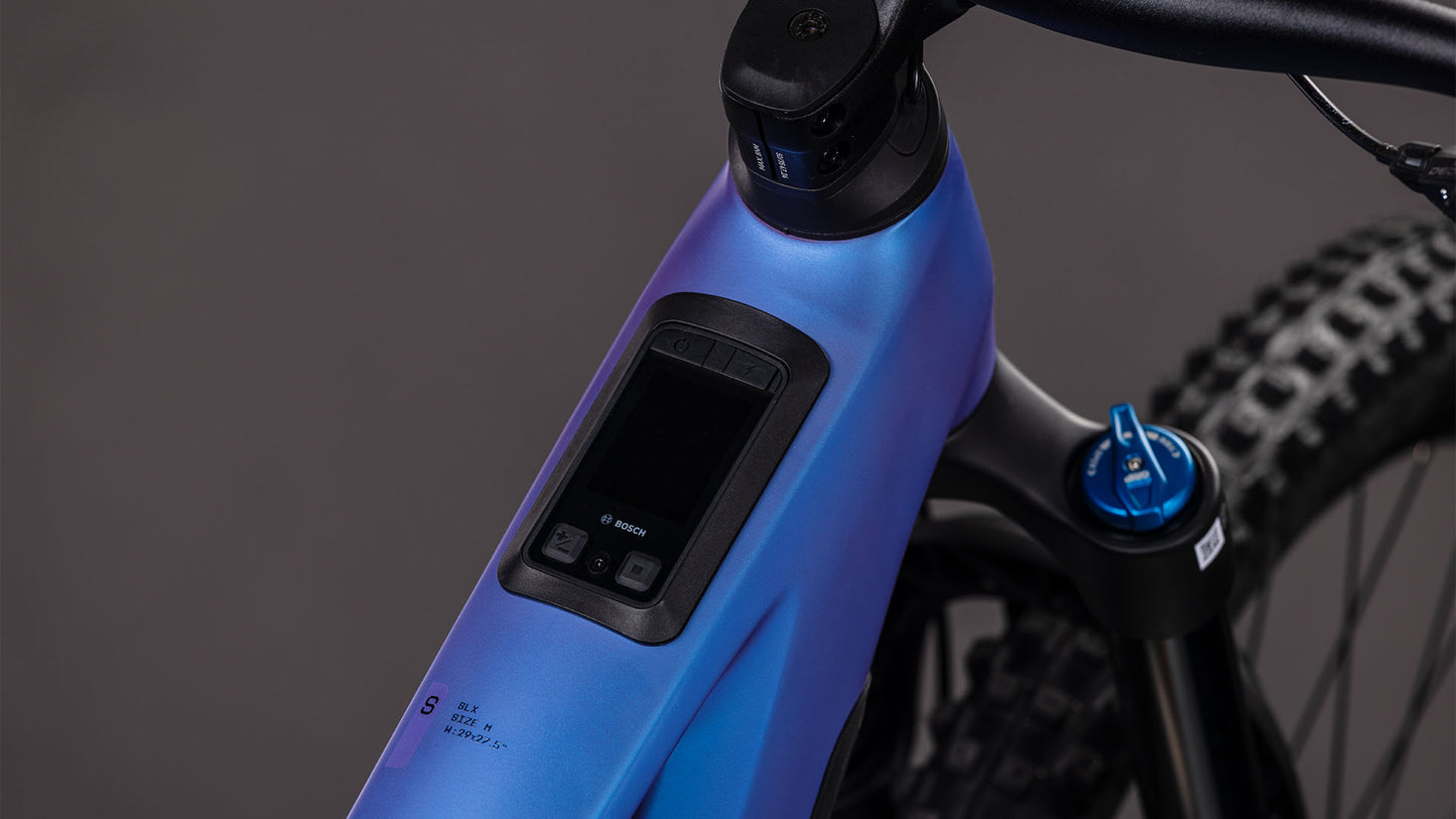 Nahaufnahme des Cube Stereo Hybrid ONE77 HPC SLX 800 blueiris'n'black 2026 von CUBE. Hervorzuheben sind das Bosch-Display am Oberrohr, der leistungsstarke Bosch CX-Motor und die Fox Float 38 Rhythm-Gabel am Lenker.