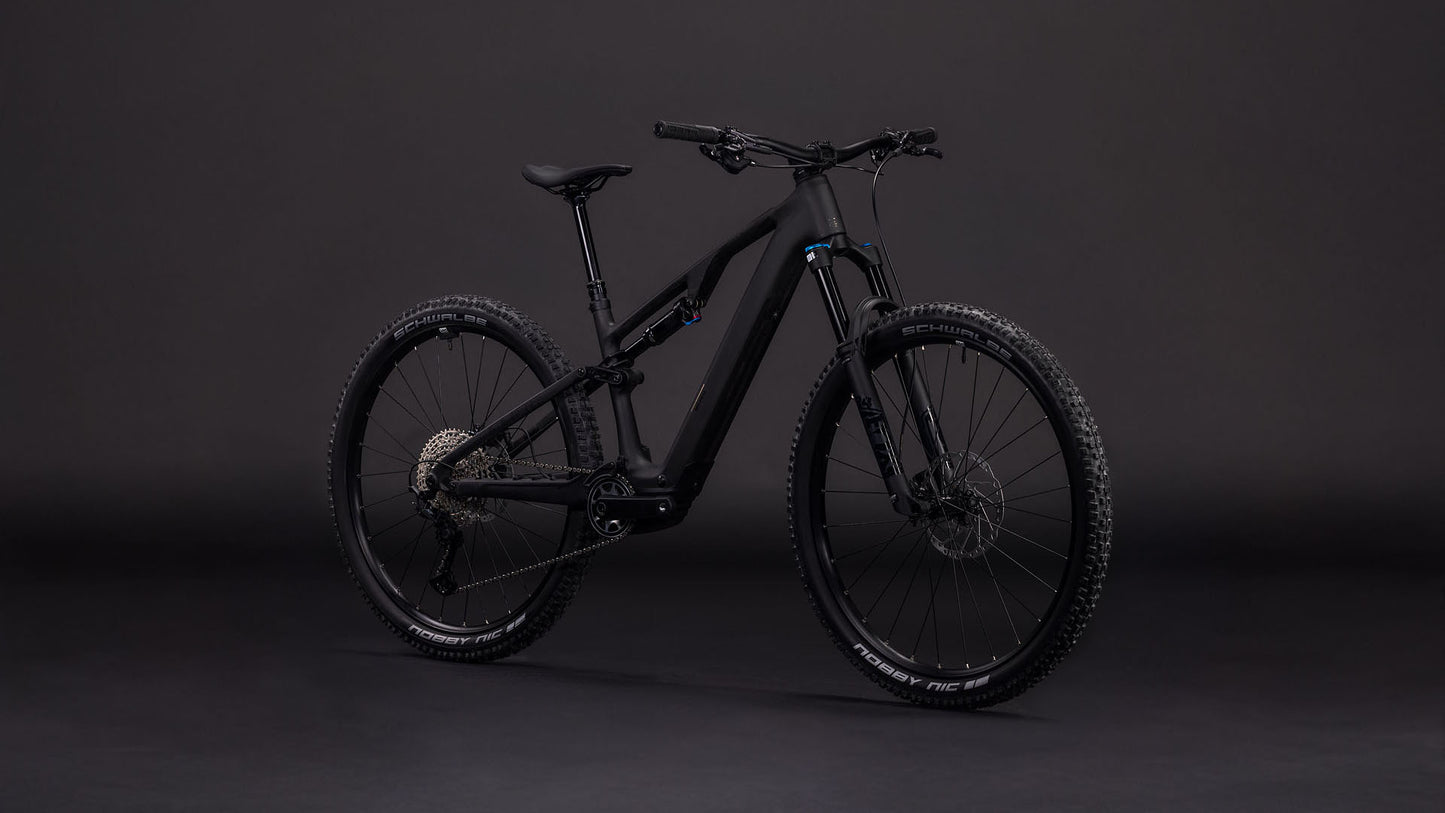 Das CUBE AMS Hybrid ONE44 C:62 Pro 400X blackline 2026 Mountainbike verfügt über einen robusten Carbonrahmen, dicke Reifen und einen Bosch SX Antrieb, der vor einem dunklen Hintergrund präsentiert wird, um das elegante schwarze Design und die fortschrittlichen Komponenten zu betonen.