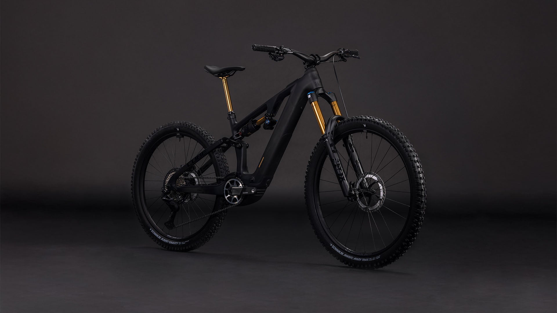 Das CUBE AMS Hybrid 177 C:62 AT 600X carbon'n'gold 2026 ist ein modernes, schwarzes Mountainbike mit Bosch CX-R Motor, Vorder- und Hinterradaufhängung, Stollenreifen und goldenen Gabelakzenten, dargestellt vor einem dunklen, nahtlosen Hintergrund.