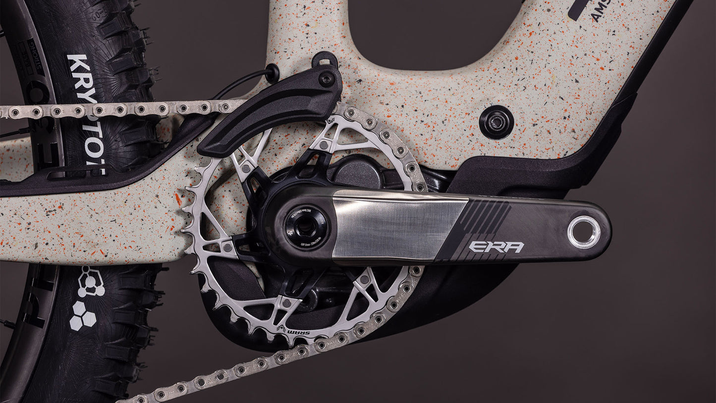 Nahaufnahme des CUBE AMS Hybrid 177 C:62 SUPER TM 600X reedbeigegrit'n'orange 2026 E-MTB's ERA Kurbelgarnitur, Metallarm, großes Kettenblatt, Bosch CX-R Motor, 170 mm Federweg, gesprenkeltes cremefarbenes Rahmenfinish und Hinterreifen.