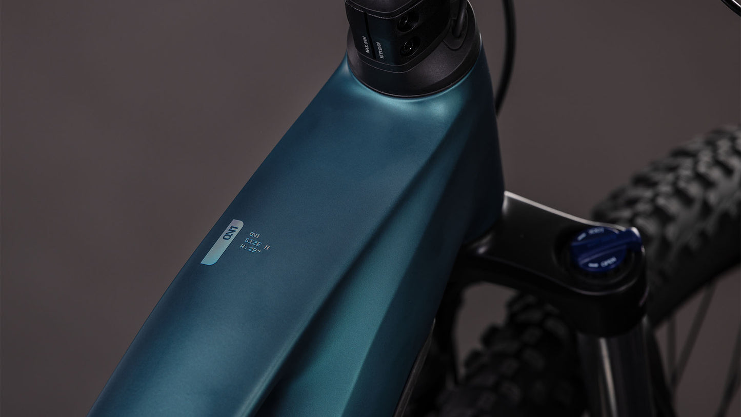 Nahaufnahme des CUBE Reaction Hybrid ONE 800 (2026) in royalgreen'n'prism, die das schlanke Oberrohr, die Federgabel, den integrierten 800-Wh-Akku, das dezente CUBE-Branding und einen Teil des knorrigen Vorderradreifens zeigt.