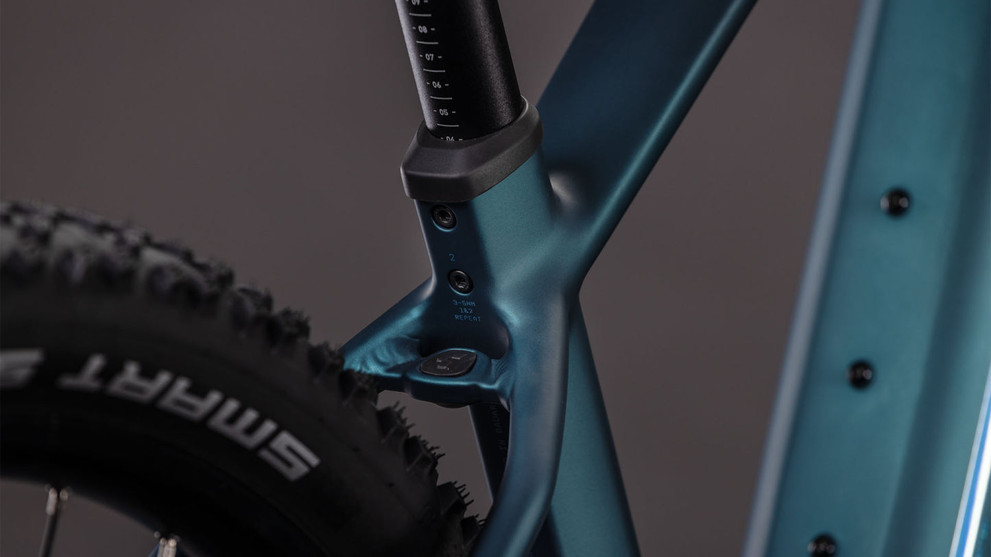Nahaufnahme eines CUBE Reaction Hybrid ONE 800 royalgreen'n'prism 2026 Fahrradrahmens, mit Fokus auf den Sitzrohrübergang und den Hinterreifen, Hervorhebung der detaillierten Rahmenkonstruktion und eines Teils der Sattelstütze mit Messmarkierungen.