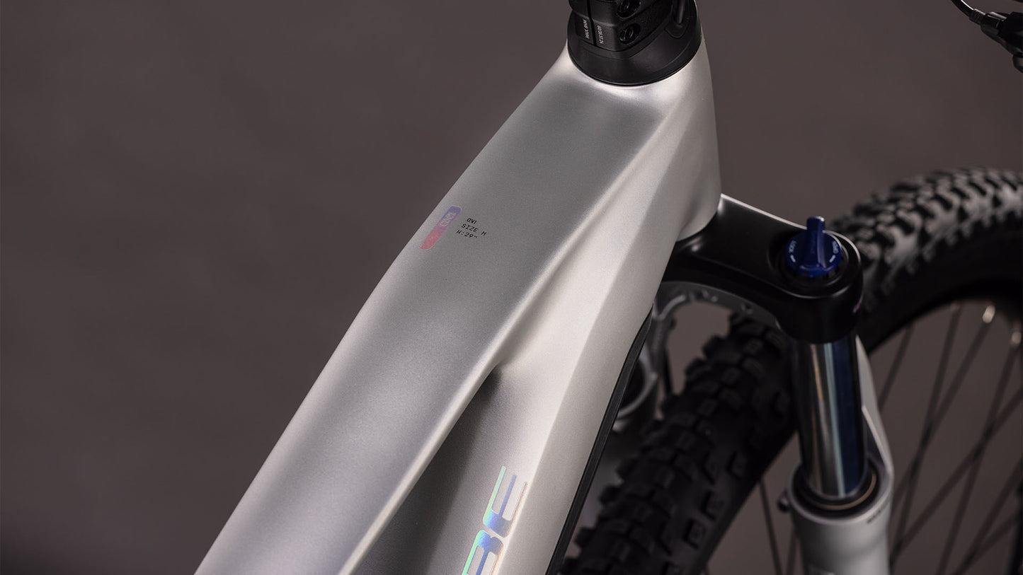 Nahaufnahme des matt-silbernen Rahmens und der Federgabel des CUBE Reaction Hybrid ONE 800 sleekgrey'n'prism 2026, die das glatte, kantige Design, den integrierten Bosch-Motor und die Stollenreifen zeigt.