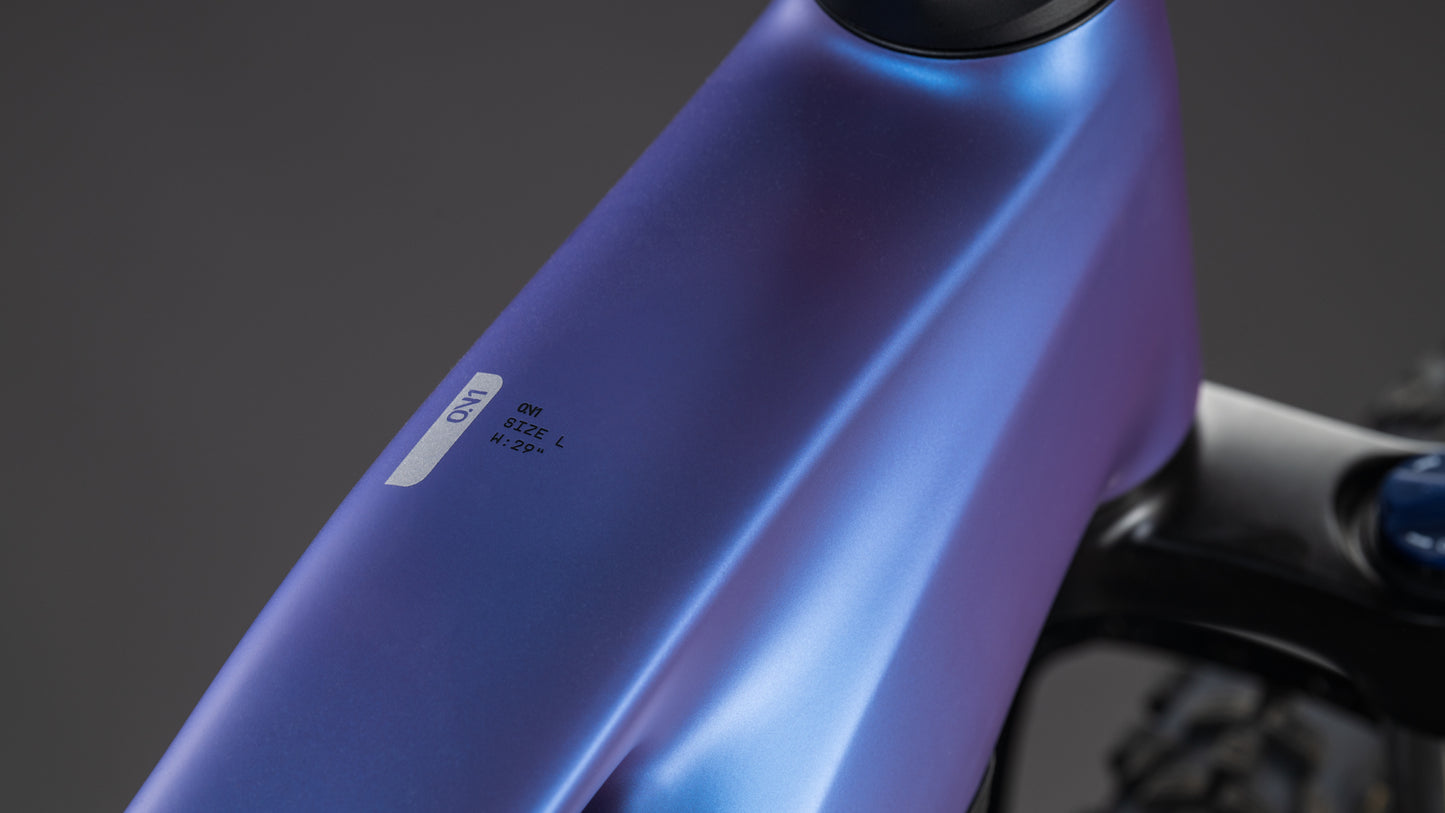 Nahaufnahme des metallisch blauen CUBE Reaction Hybrid ONE 800 (blueiris'n'reflect, GRÖSSE: L und M 22.2), mit Shimano Cues Schaltung, vor einem unscharfen dunklen Hintergrund - perfekt ausgestattet für jede Fahrt.