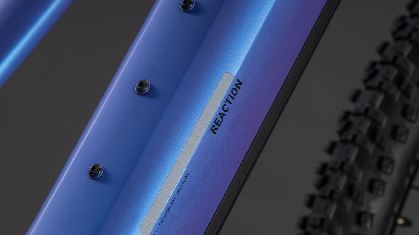 Nahaufnahme des CUBE Reaction Hybrid ONE 800 blueiris'n'reflect Trapeze 2026 Rahmens mit REACTION Branding, schwarzen Noppenreifen, Befestigungspunkten und Platz für einen 800 Wh Akku - ideal für ausgedehnte Fahrten.