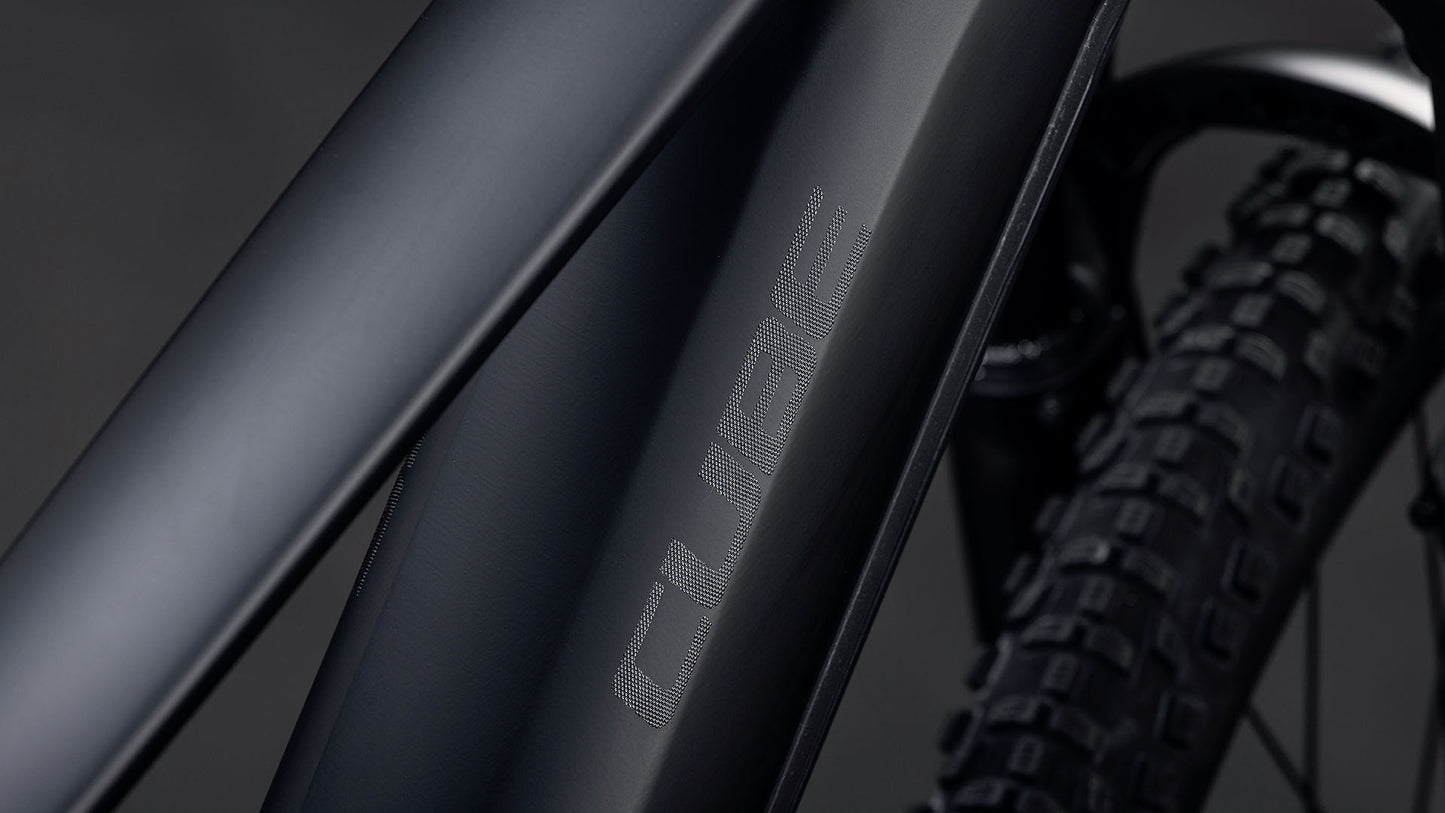 Nahaufnahme des Cube Reaction Hybrid Pro 800 blackline 2026 Rahmens in mattschwarz von CUBE, mit sichtbarem strukturierten Reifen und angedeutetem leistungsstarken Bosch CX Antrieb plus 800 Wh Akku im Hintergrund.