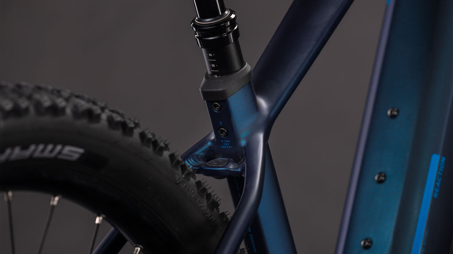 Nahaufnahme des CUBE Reaction Hybrid Pro 800 nebular'n'dazzle 2026 E-MTB-Rahmens, mit Hervorhebung von Sattelrohr, Sattelstütze und Schwalbe-Hinterradreifen. Ausgestattet mit Bosch CX Antrieb und 800 Wh Akku vor einem dunklen Hintergrund.