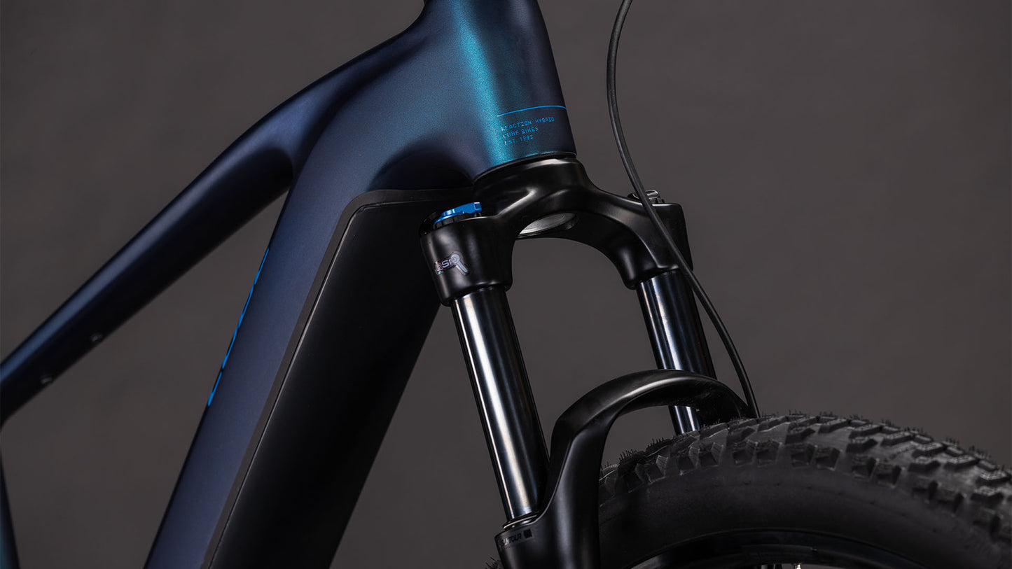 Nahaufnahme des CUBE Reaction Hybrid Pro 800 nebular'n'dazzle 2026 E-Mountainbike mit Federgabel und Reifen, die den matten dunkelblauen Rahmen mit Shimano XT 12-fach Schaltung vor einem schlichten dunklen Hintergrund zeigen.