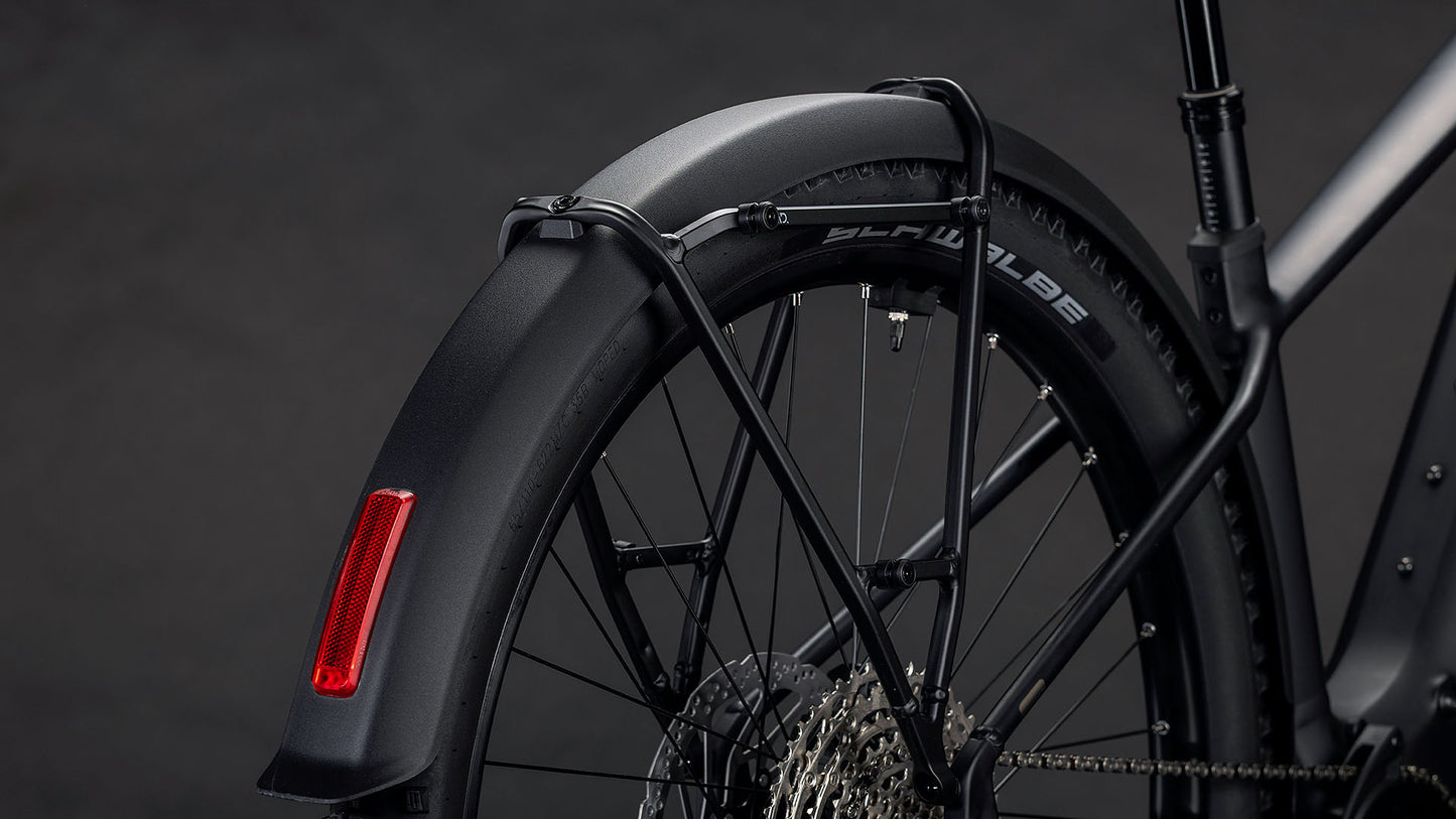 Nahaufnahme des Hinterrads des CUBE Reaction Hybrid Pro 800 FE blackline 2026 mit der Shimano XT Schaltung, dem schwarzen Schutzblech, dem roten Reflektor und dem Rahmen vor dunklem Hintergrund.