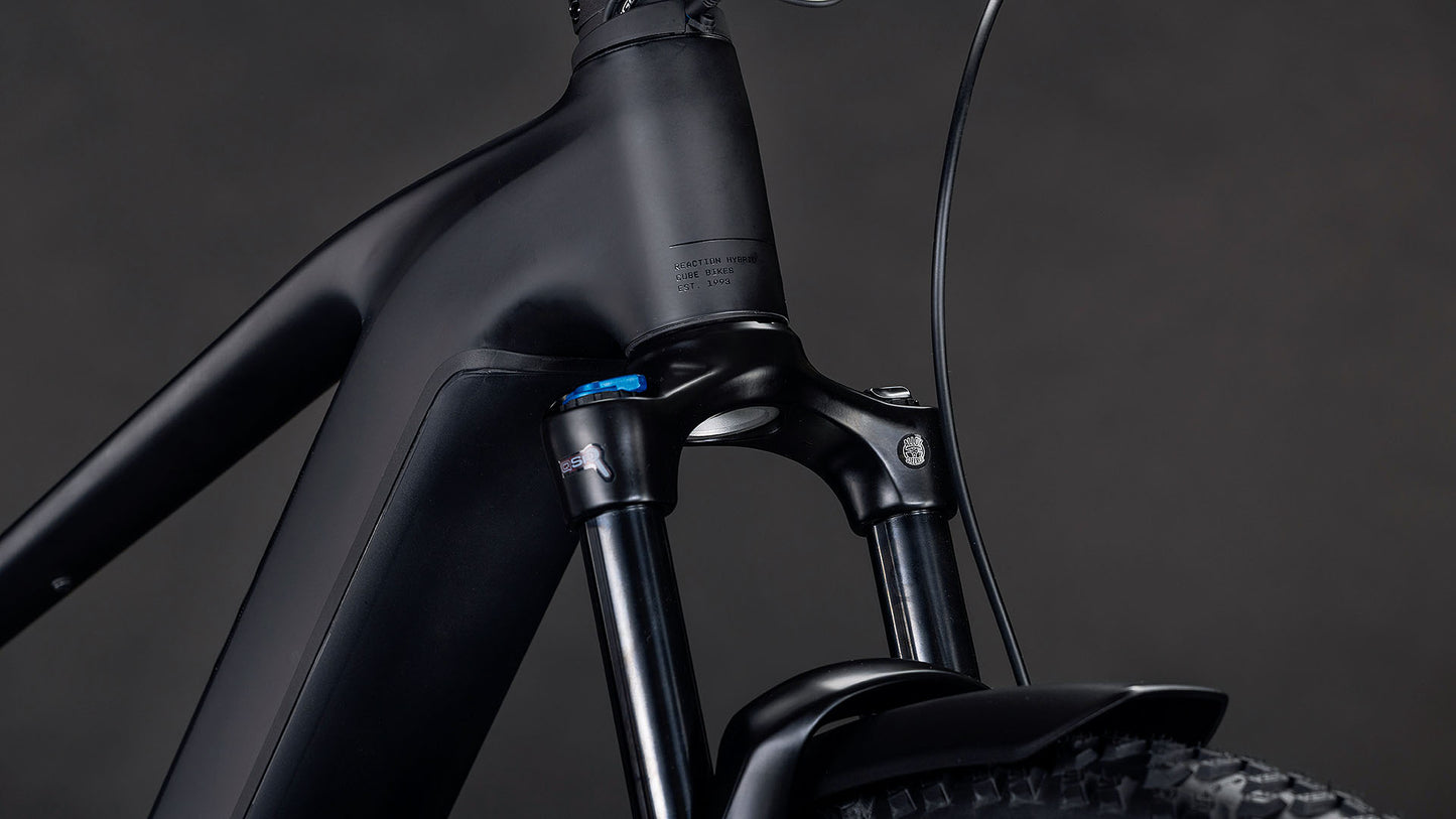 Nahaufnahme des mattschwarzen E-Bike-Rahmens CUBE Reaction Hybrid Pro 800 FE blackline 2026 mit Federgabel, Teilbereifung und Bremszug vor dunklem Hintergrund.