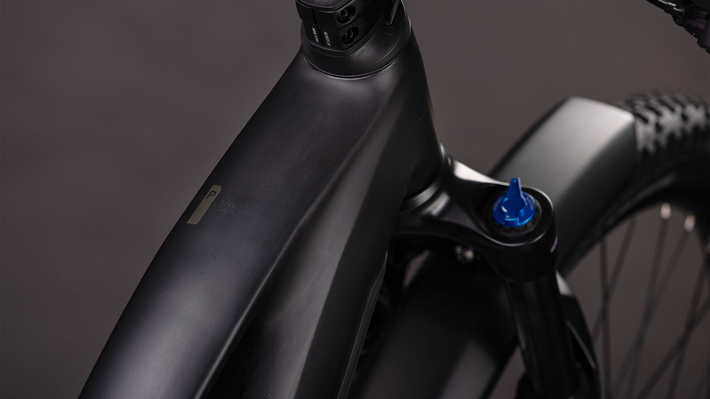 Nahaufnahme des CUBE Reaction Hybrid Pro 800 FE blackline Trapeze 2026, die den mattschwarzen Rahmen, das Oberrohr, den Steuersatz, den blauen Knopf der Vorderradaufhängung, die Shimano XT 12-Gang-Schaltung und einen Teil des Vorderrads zeigt.