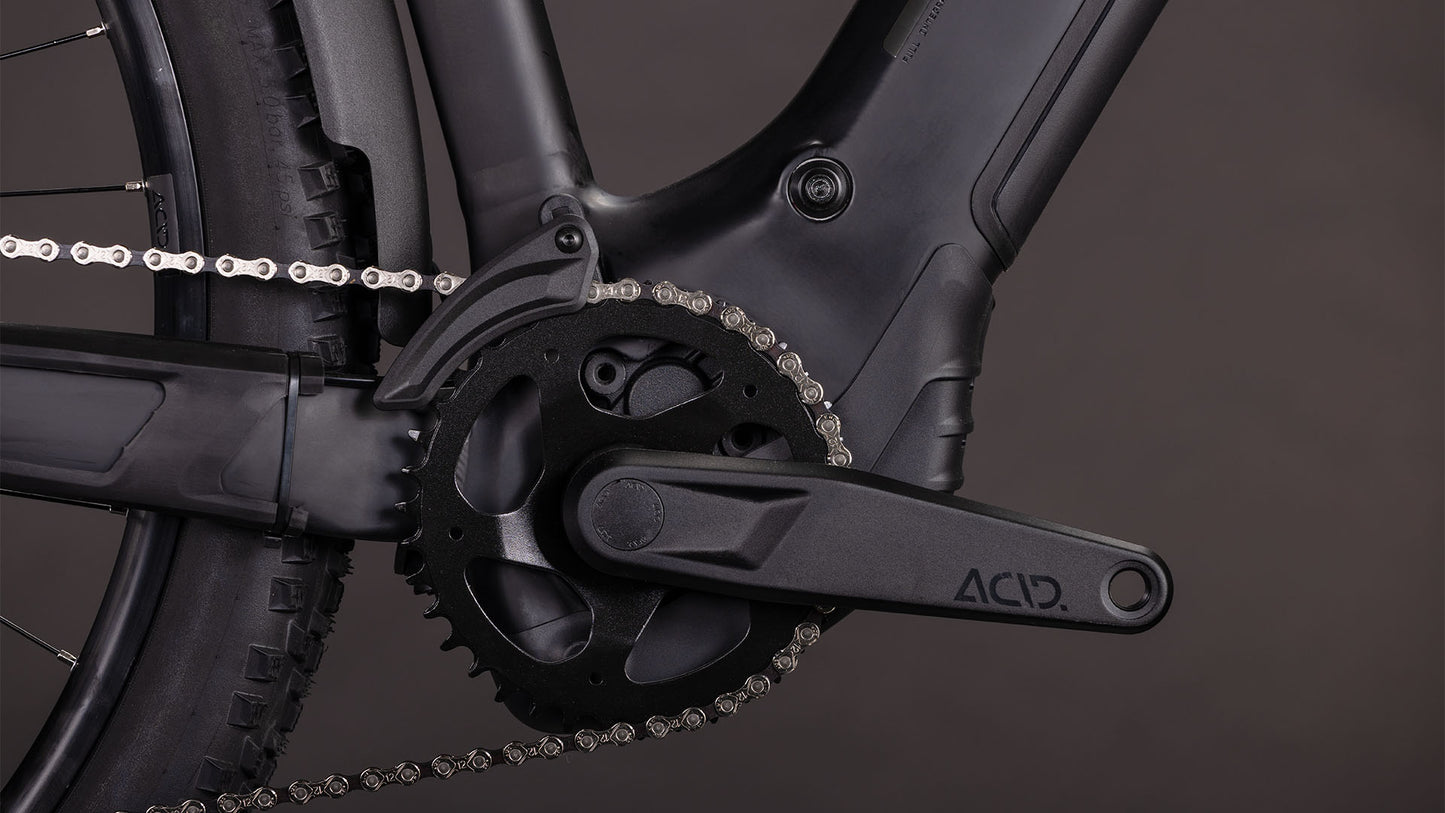 Nahaufnahme der CUBE Reaction Hybrid Pro 800 FE blackline Trapeze 2026 Kurbelgarnitur, Kettenblatt und Kette vor einem dunklen Hintergrund, mit ACID-gekennzeichnetem Kurbelarm - entwickelt für E-Bikes mit präziser Bosch CX Motorleistung.