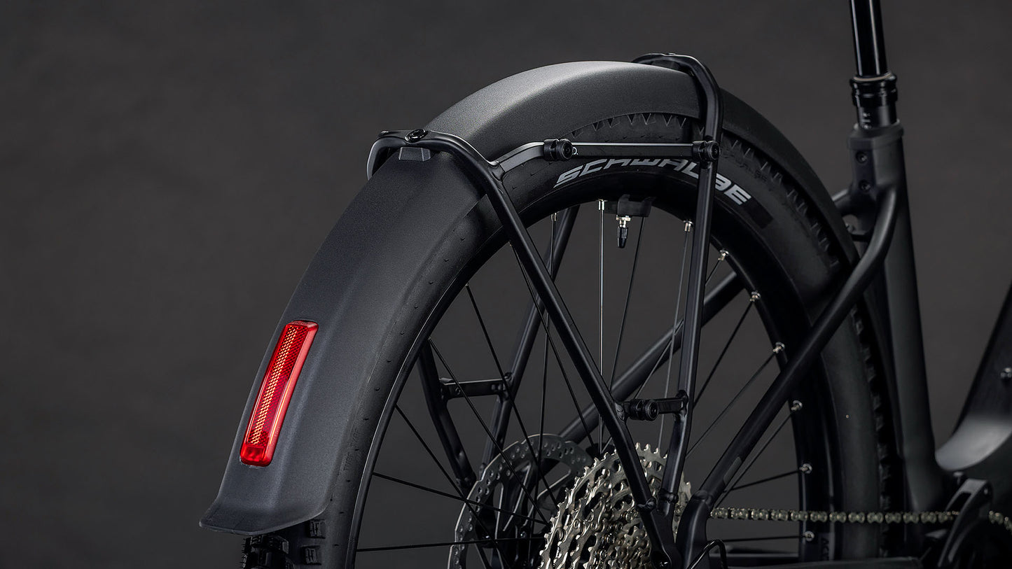 Nahaufnahme des Hinterrads des CUBE Reaction Hybrid Pro 800 FE blackline Easy Entry 2026 E-Bike mit dickem Reifen, schwarzem Schutzblech mit rotem Reflektor, Shimano XT 12-fach Schaltung Kassette und Speichen vor dunklem Hintergrund.