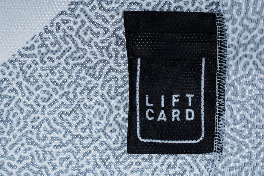 Nahaufnahme eines schwarzen Stoffanhängers mit "LIFT CARD" in weiß, aufgenäht auf das CUBE VERTEX Rundhalstrikot langarm schwarz von Cube-perfekt als Liftkartentasche und kompatibel mit Neck-Brace.