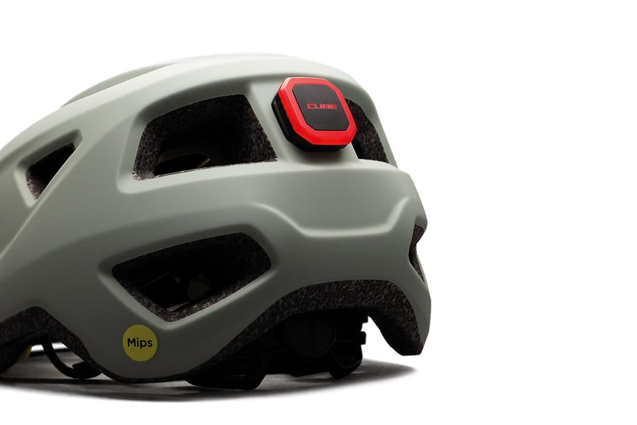 Eine Nahaufnahme des Cube CUBE Helm Rücklicht CMPT, ein grauer Fahrradhelm mit rotem Rücklicht und gelbem Mips-Sicherheitsaufkleber, fotografiert vor weißem Hintergrund, ist bei Radfahrern in Niedersachsen beliebt.