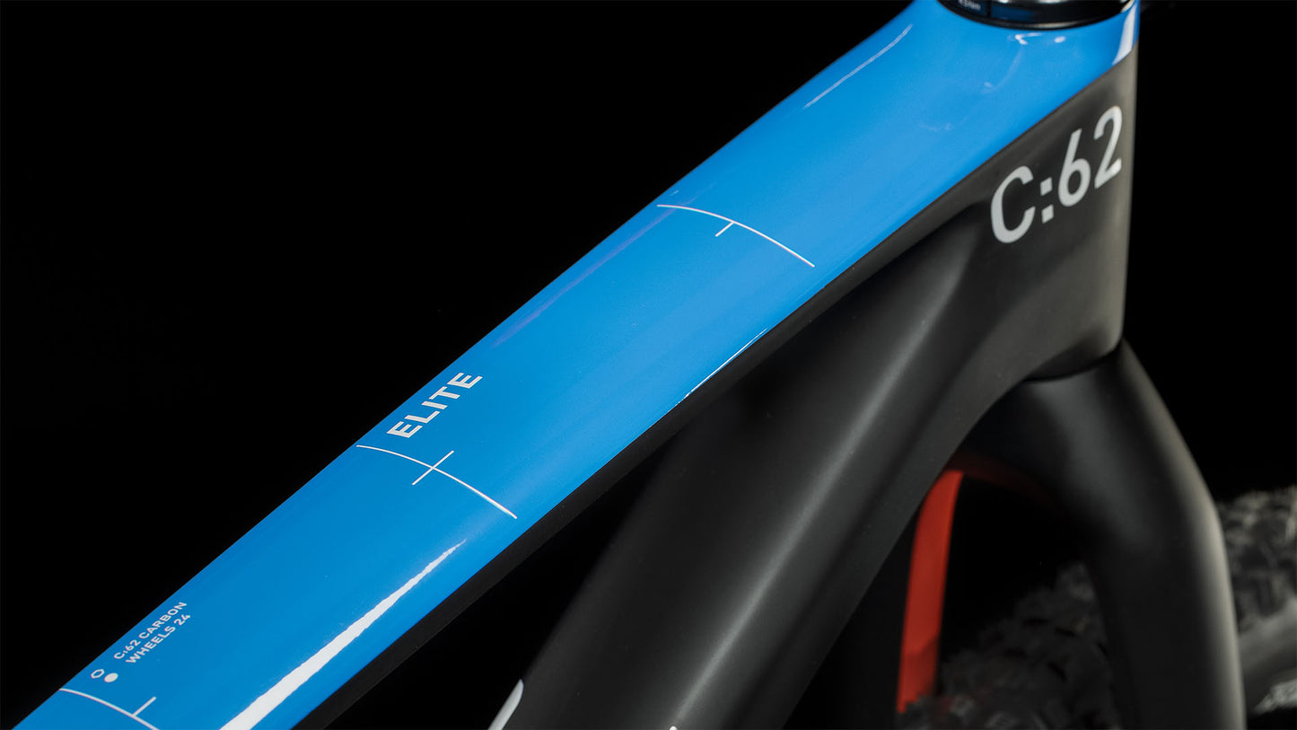 Nahaufnahme des CUBE Elite 240 C:62 Pro carbon'n'blue'n'red 2024 Mountainbike mit blauem, glänzendem Oberrohr mit der Aufschrift ELITE und C:62, mit mattschwarzen und roten Akzenten vor schwarzem Hintergrund. Marke: CUBE.