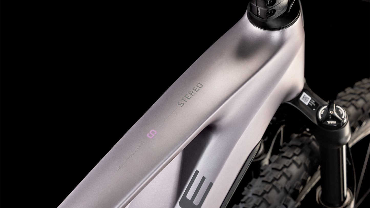 Nahaufnahme des CUBE Stereo Hybrid ONE22 SLX 800 lilacbreeze'n'reflect 2025 Rahmens mit STEREO auf dem Oberrohr, dem Lenkervorbau, der Federgabel, dem Hinterradreifen und dem leistungsstarken Bosch CX Motor vor schwarzem Hintergrund.