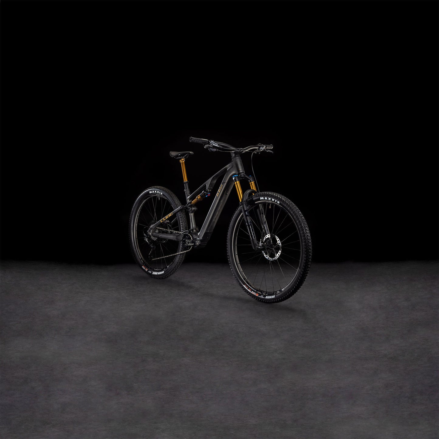 Das CUBE AMS Hybrid ONE44 C:68X SLT 400X 29 carbon'n'golddust 2025 präsentiert sich vor einem dunklen Hintergrund, der seine goldenen Akzente, die robusten Reifen und den fortschrittlichen C:68X Carbonrahmen hervorhebt.