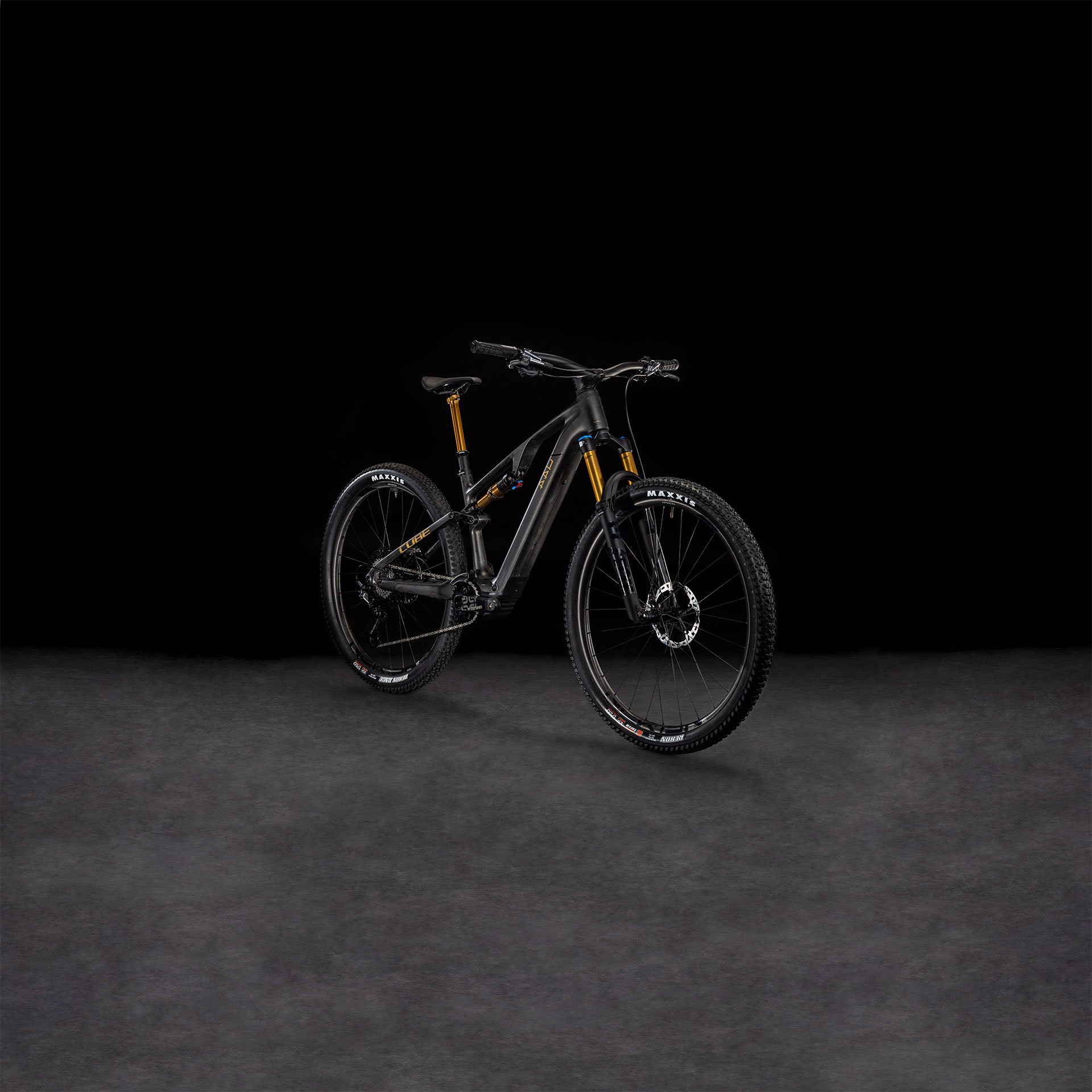 Das CUBE AMS Hybrid ONE44 C:68X SLT 400X 29 carbon'n'golddust 2025 präsentiert sich vor einem dunklen Hintergrund, der seine goldenen Akzente, die robusten Reifen und den fortschrittlichen C:68X Carbonrahmen hervorhebt.