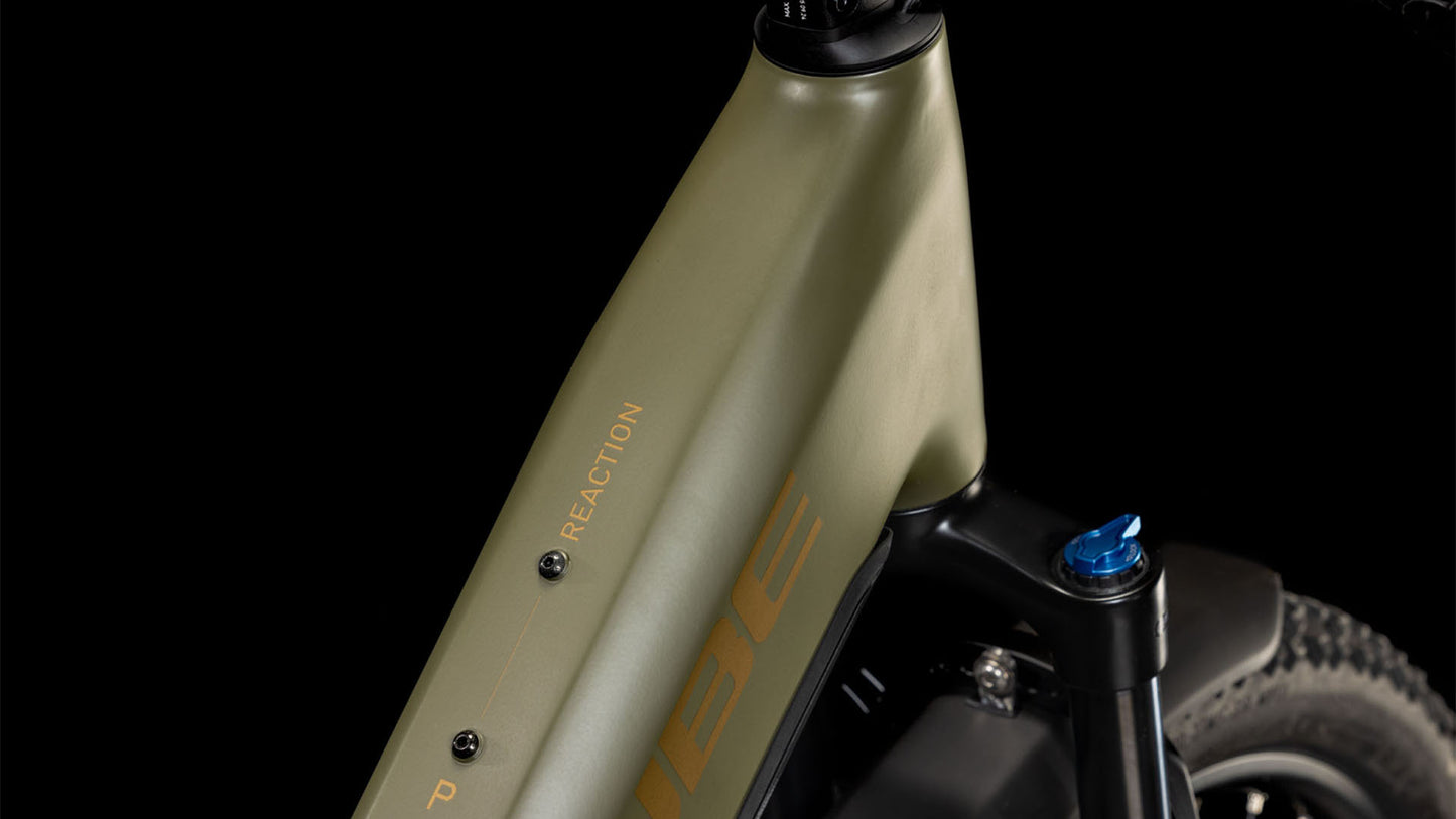 Nahaufnahme des Vorderrahmens und der Federgabel des CUBE Reaction Hybrid Pro 800 Allroad Easy Entry 2025 in staubig-goldener Farbe mit Bosch-Motor und "Reaction"-Schriftzug vor schwarzem Hintergrund.