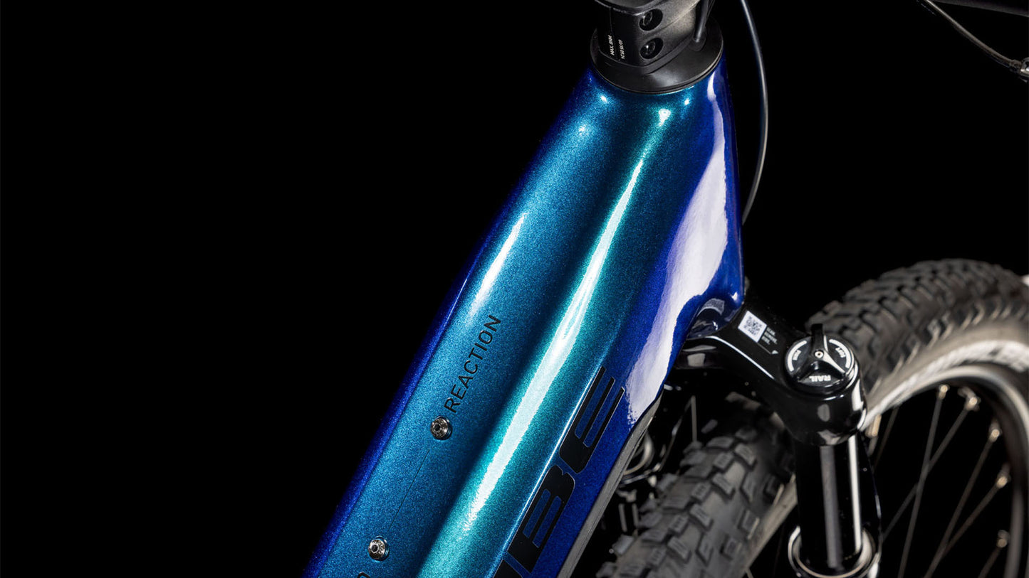 Nahaufnahme des CUBE Reaction Hybrid SLX 800 nebula'n'blue Easy Entry 2025 Fahrradrahmens mit REACTION-Branding, die einen Teil der Federgabel und des Reifens vor einem schwarzen Hintergrund zeigt.