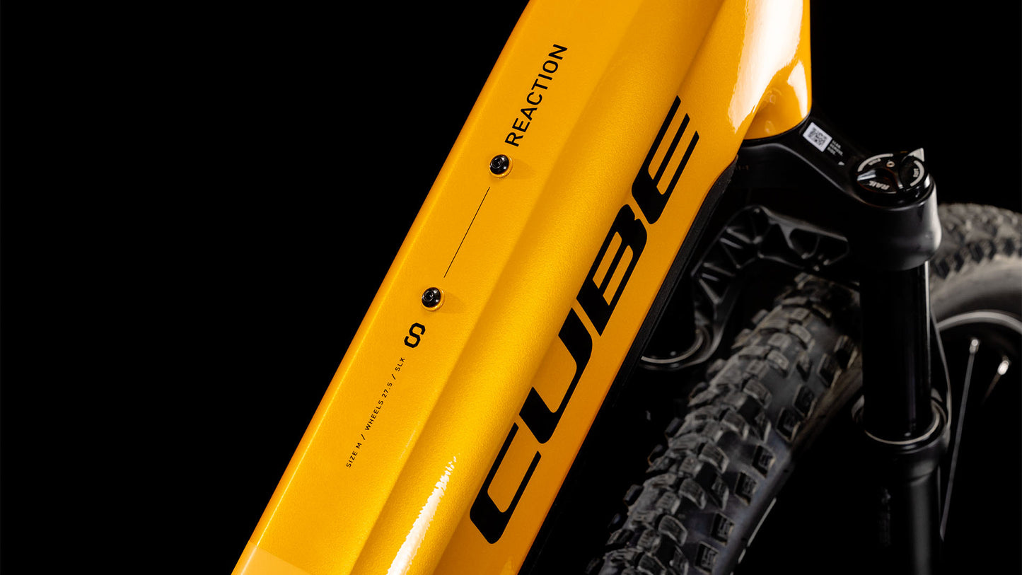 Nahaufnahme eines gelben CUBE Cube Reaction Hybrid SLX 800 spectraorange´n´violet Easy Entry 2025-Rahmens, der die Details und den Vorderreifen vor einem schwarzen Hintergrund hervorhebt.