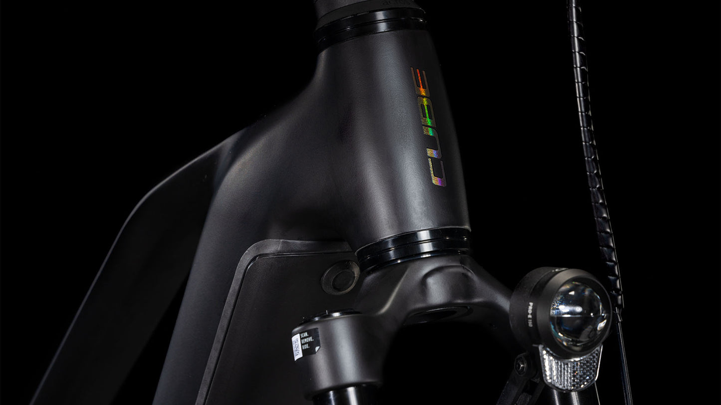 Nahaufnahme eines CUBE Kathmandu Hybrid EXC 800 black'n'prism Trapeze 2025 Rahmens mit Gabel, Frontscheinwerfer und einem bunten vertikalen Logo auf dem Steuerrohr, alles vor einem schwarzen Hintergrund.