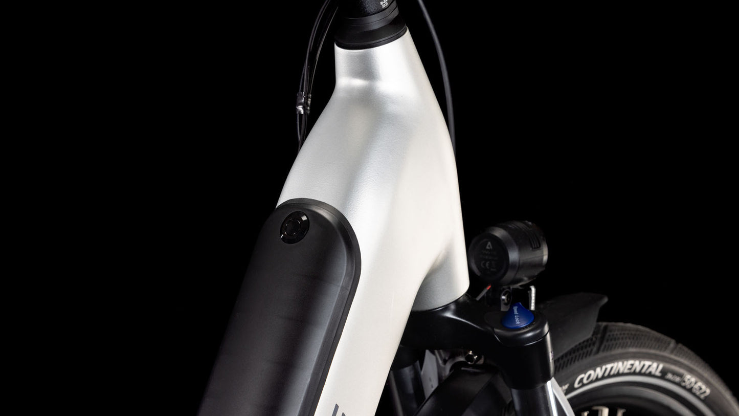 Nahaufnahme des Vorderrahmens des CUBE Supreme RT Hybrid Comfort EXC 625 sleekgrey´n´lunar Easy Entry 2025. Zu sehen sind die silberne Karosserie, der integrierte 625-Wh-Akku, die Vorderradfederung und der Continental-Reifen vor einem schwarzen Hintergrund.