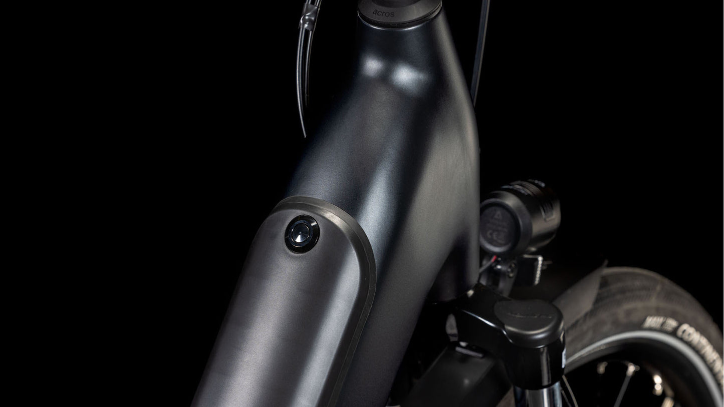 Nahaufnahme des glänzend metallschwarzen Cube Supreme RT Hybrid Deluxe EX 625 Easy Entry 2025 Rahmens von CUBE mit dem Bosch Active Plus Motor, integriertem Scheinwerfer und einem Teil des Vorderreifens vor einem dunklen Hintergrund.