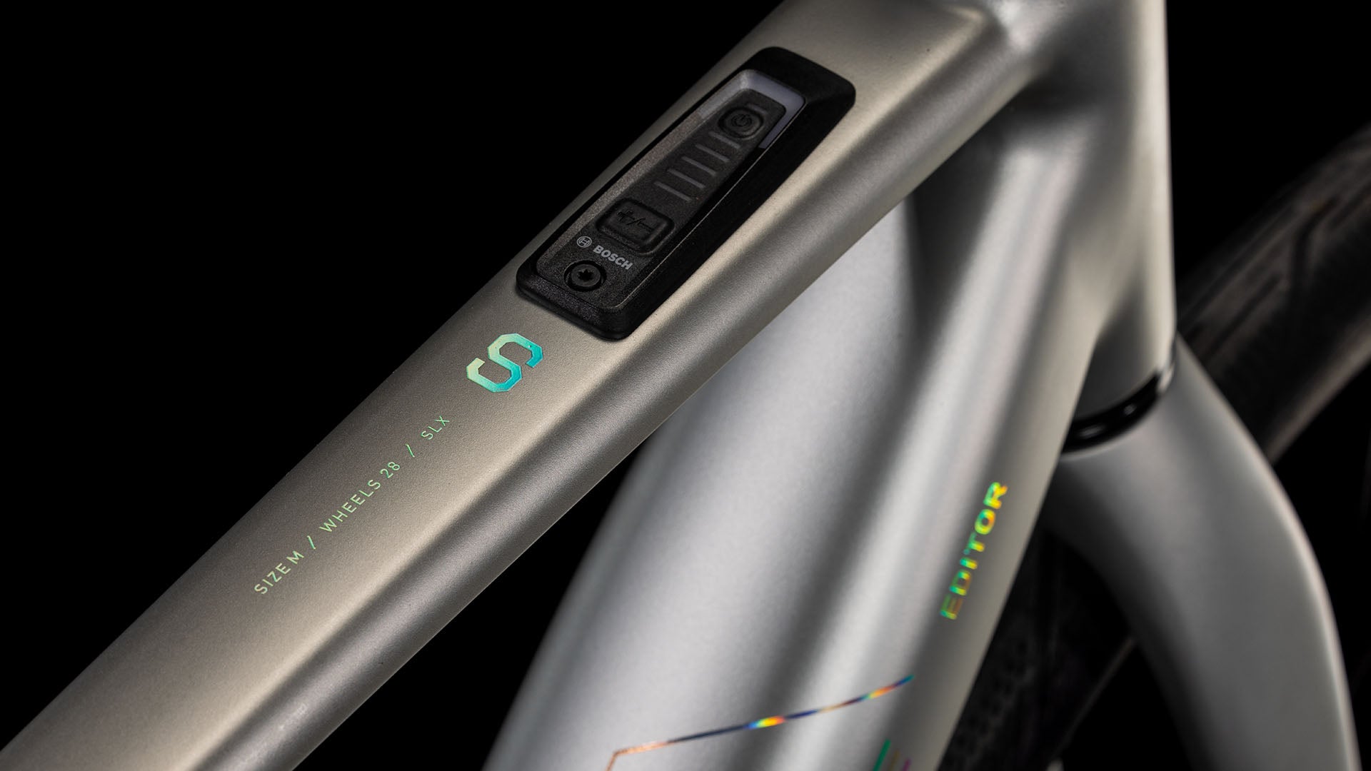 Nahaufnahme des CUBE Editor Hybrid SLX 400X sleekgrey'n'spectral 2025 Rahmens mit integriertem elektronischen Bedienfeld und dezentem CUBE Branding. Die Beschriftung lautet "SIEN / WIRELESS 1X / SLX". Mit Shimano 8-Gang Nabenschaltung.