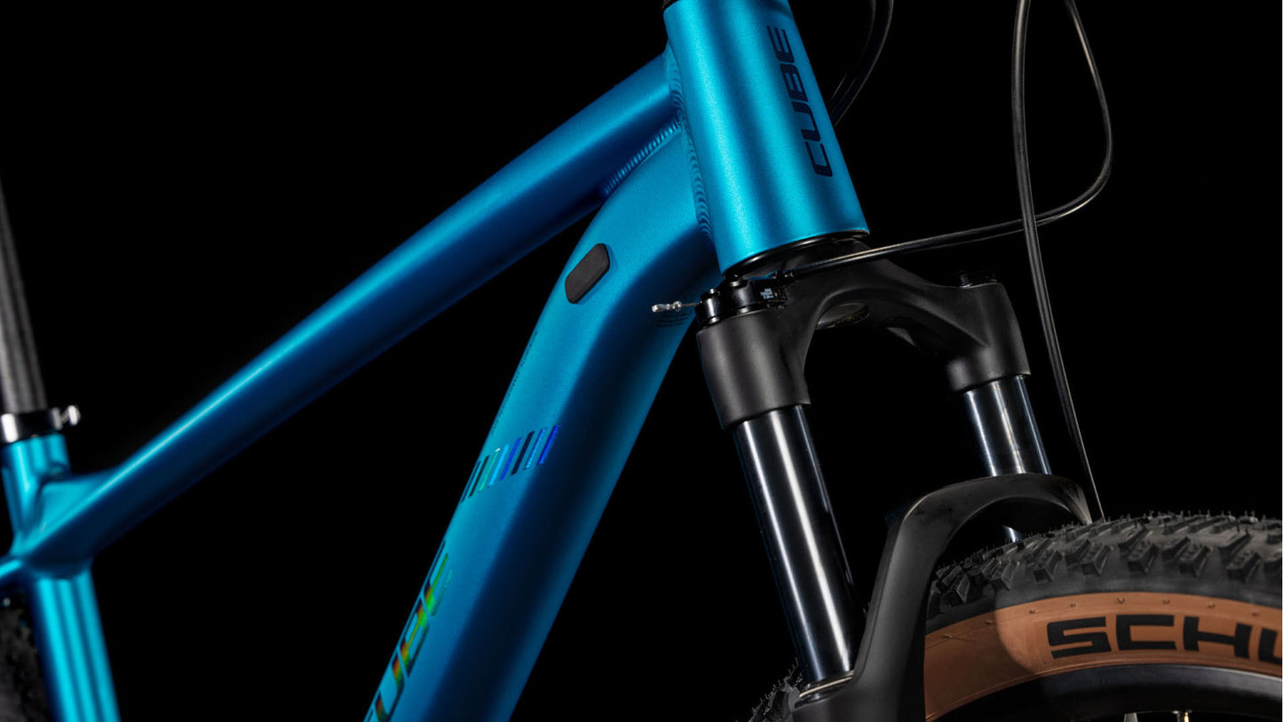 Nahaufnahme des CUBE Reaction Pro metallicteal'n'holo 2025 Mountainbike-Rahmens mit der RockShox Judy Silver Luftfedergabel und einem Schwalbe-Noppenreifen vor einem schwarzen Hintergrund.