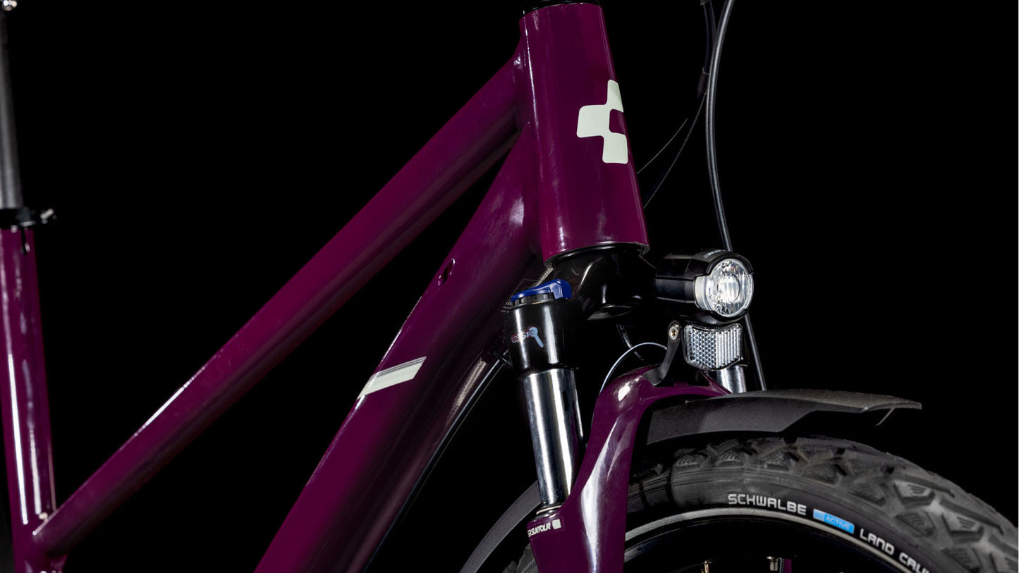 Nahaufnahme der Frontpartie eines CUBE Nature ONE Allroad amarone'n'lunar Trapeze 2025 Trekkingbike mit Federgabel, Scheinwerfer und Schwalbe-Reifen, dargestellt vor schwarzem Hintergrund.