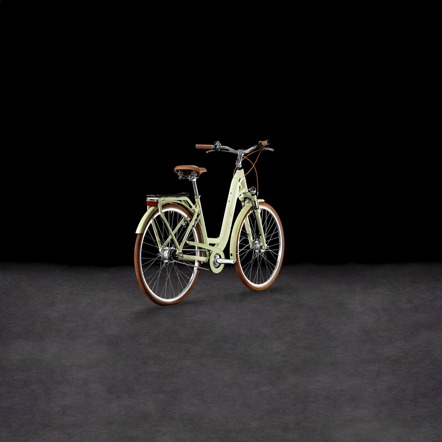 Das CUBE ella matchagreen'n'green Easy Entry 2025, ein hellgrünes Fahrrad mit braunen Reifen, Sitz, Gepäckträger und 8-Gang Nabenschaltung für mehr Komfort, steht auf einem dunklen, einfarbigen Hintergrund.